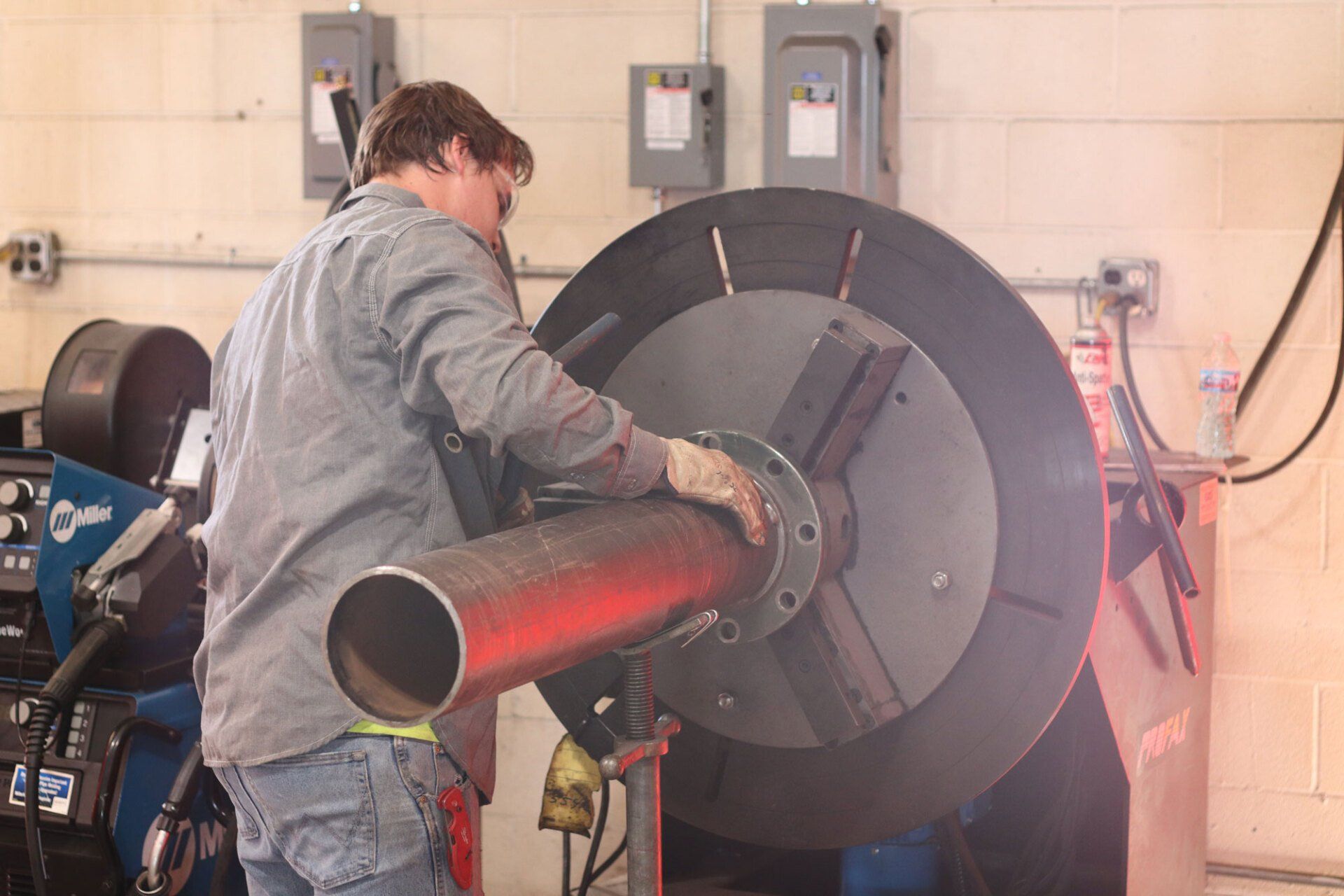a man is welding a pipe in a factory .