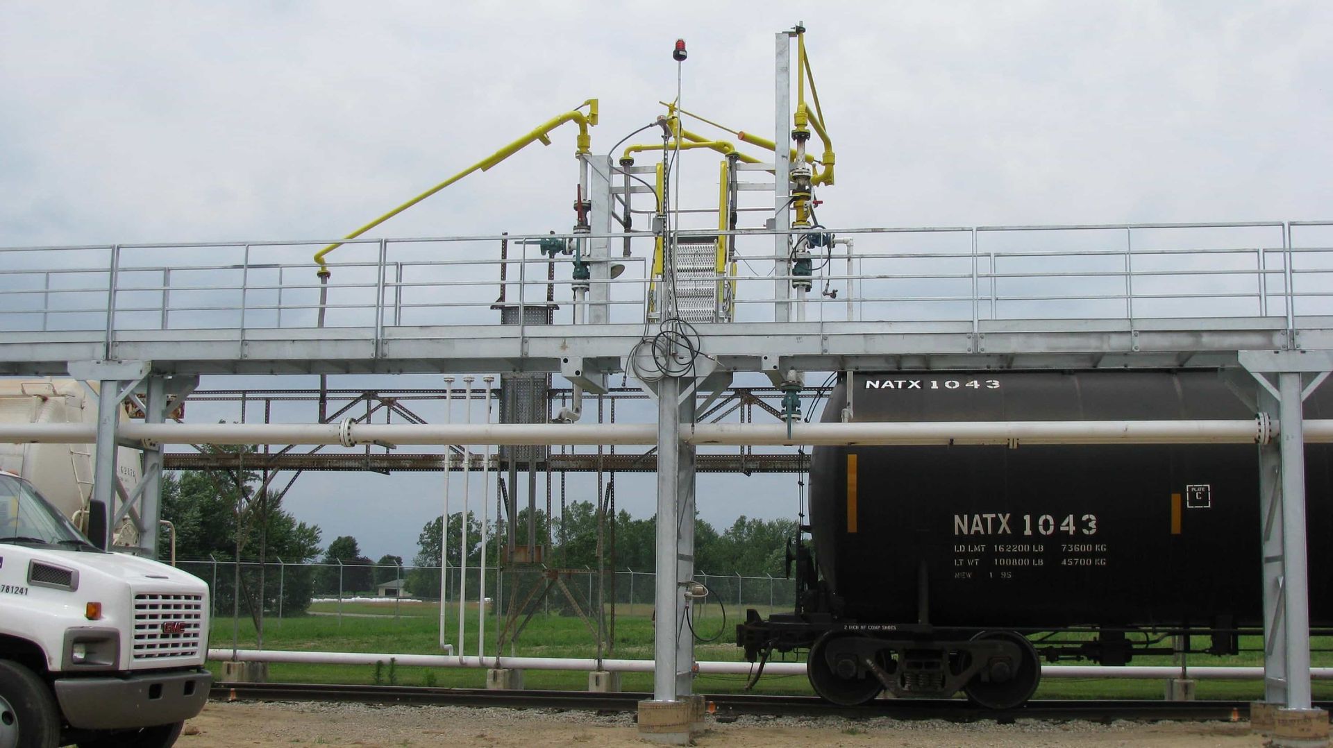 a white truck is parked in front of a train car that says n4tc 1824