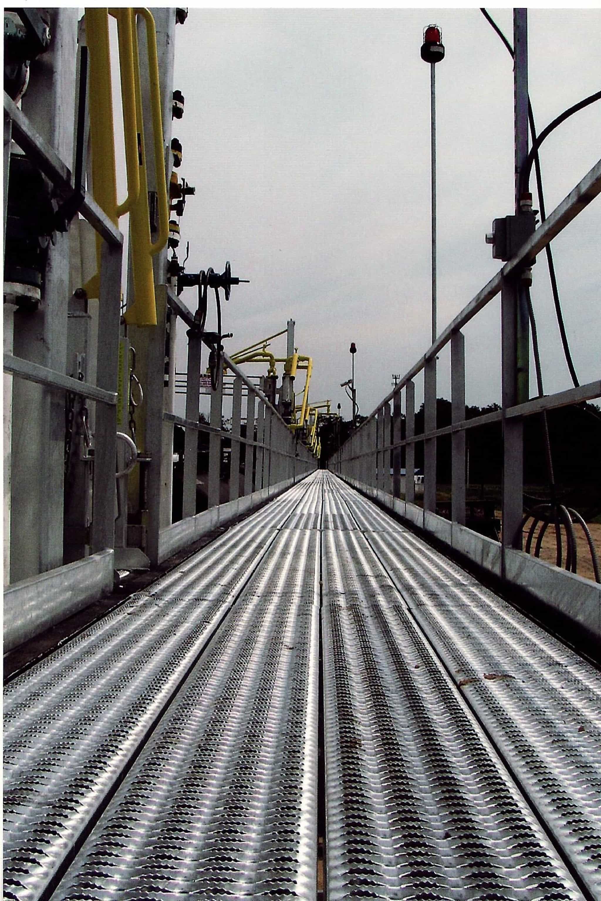 a metal walkway with a railing on the side of it