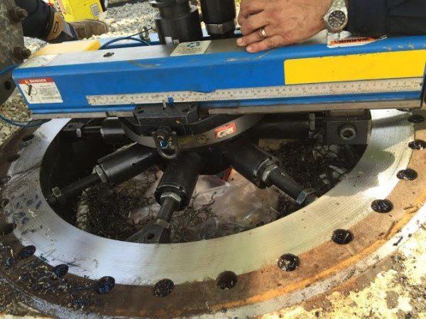 a man is using a machine to cut a piece of metal.