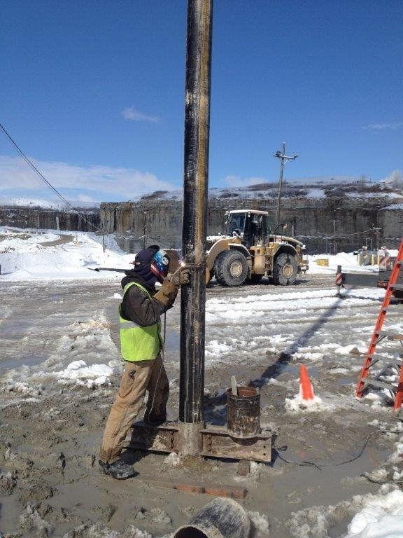a man is working on a pole with a tractor in the background