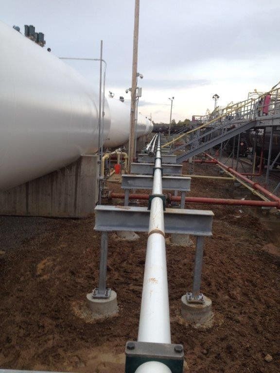 a row of white pipes are lined up in a field.
