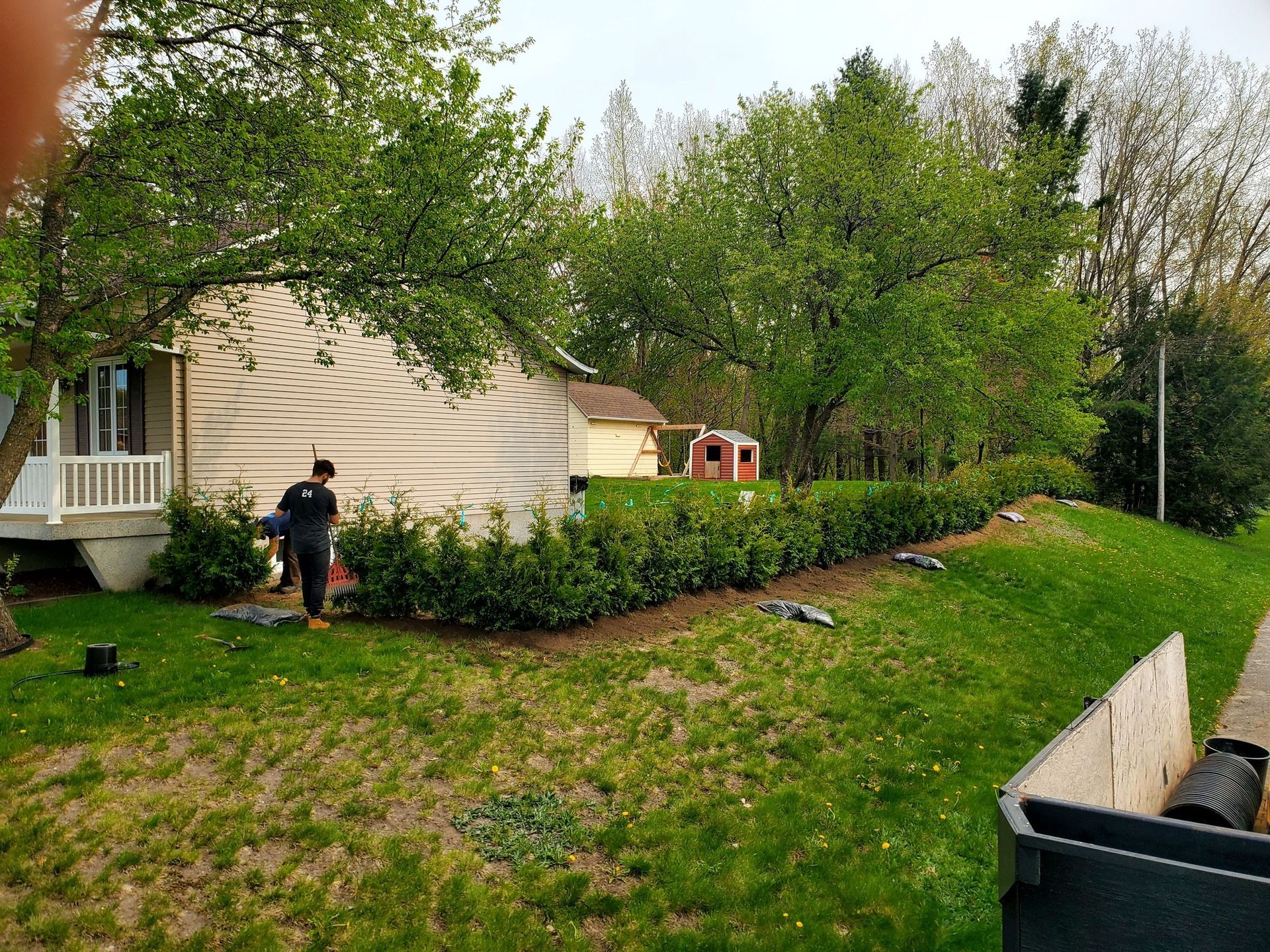Un homme se tient debout dans l'herbe devant une maison.