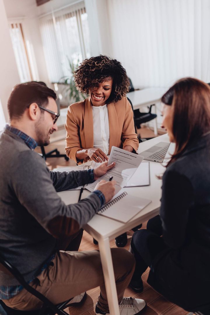 A group of people are sitting around a table looking at papers.