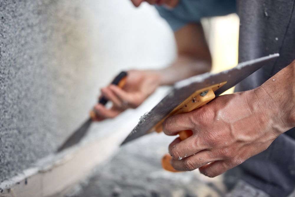 A man is cutting a piece of wood with a saw.