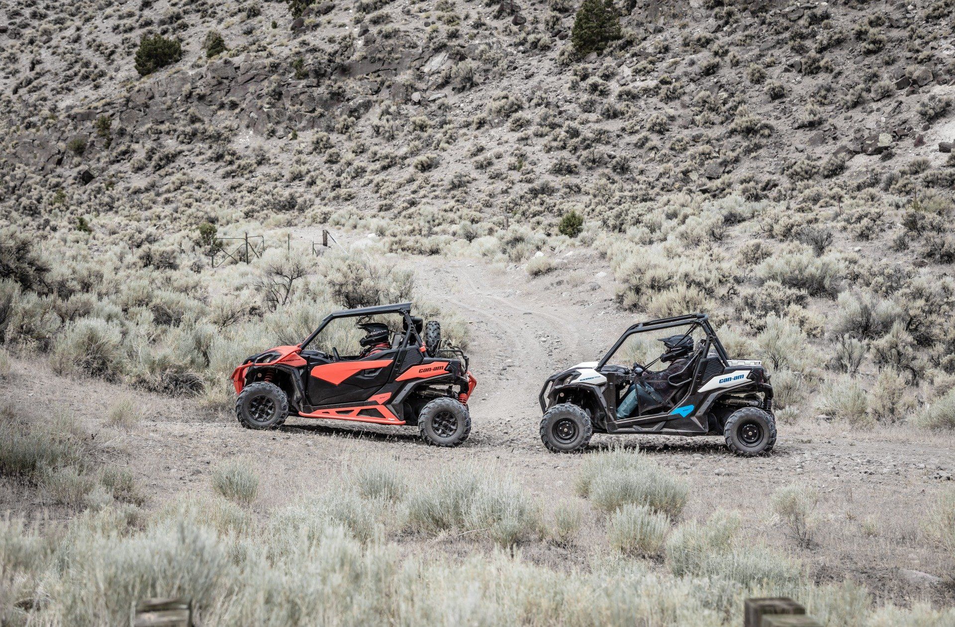 Two people riding UTV on a field