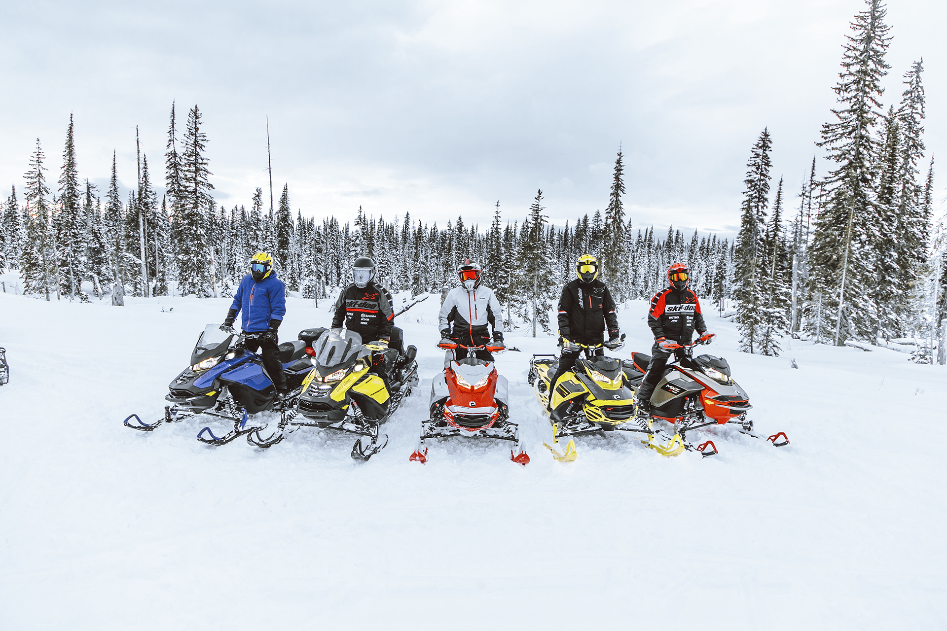 Group on snowmobiles posing for a photo