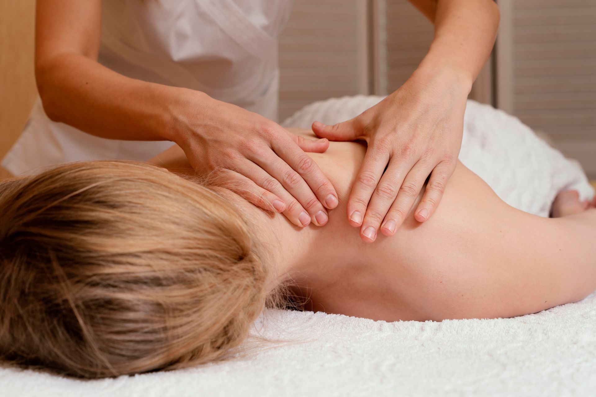 A woman is getting a massage on her back in a spa.