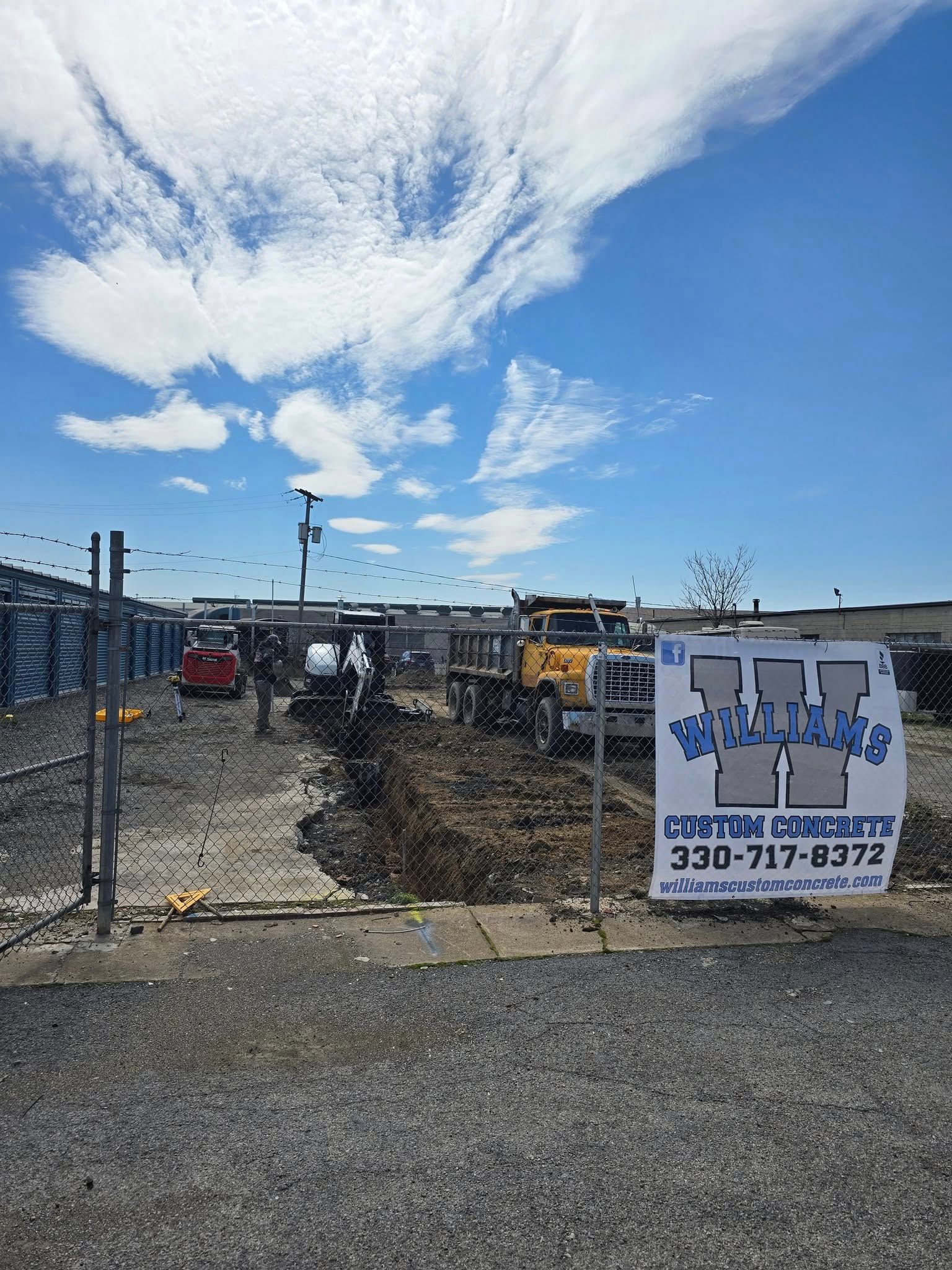 A construction site with a sign that says `` custom concrete '' on it.