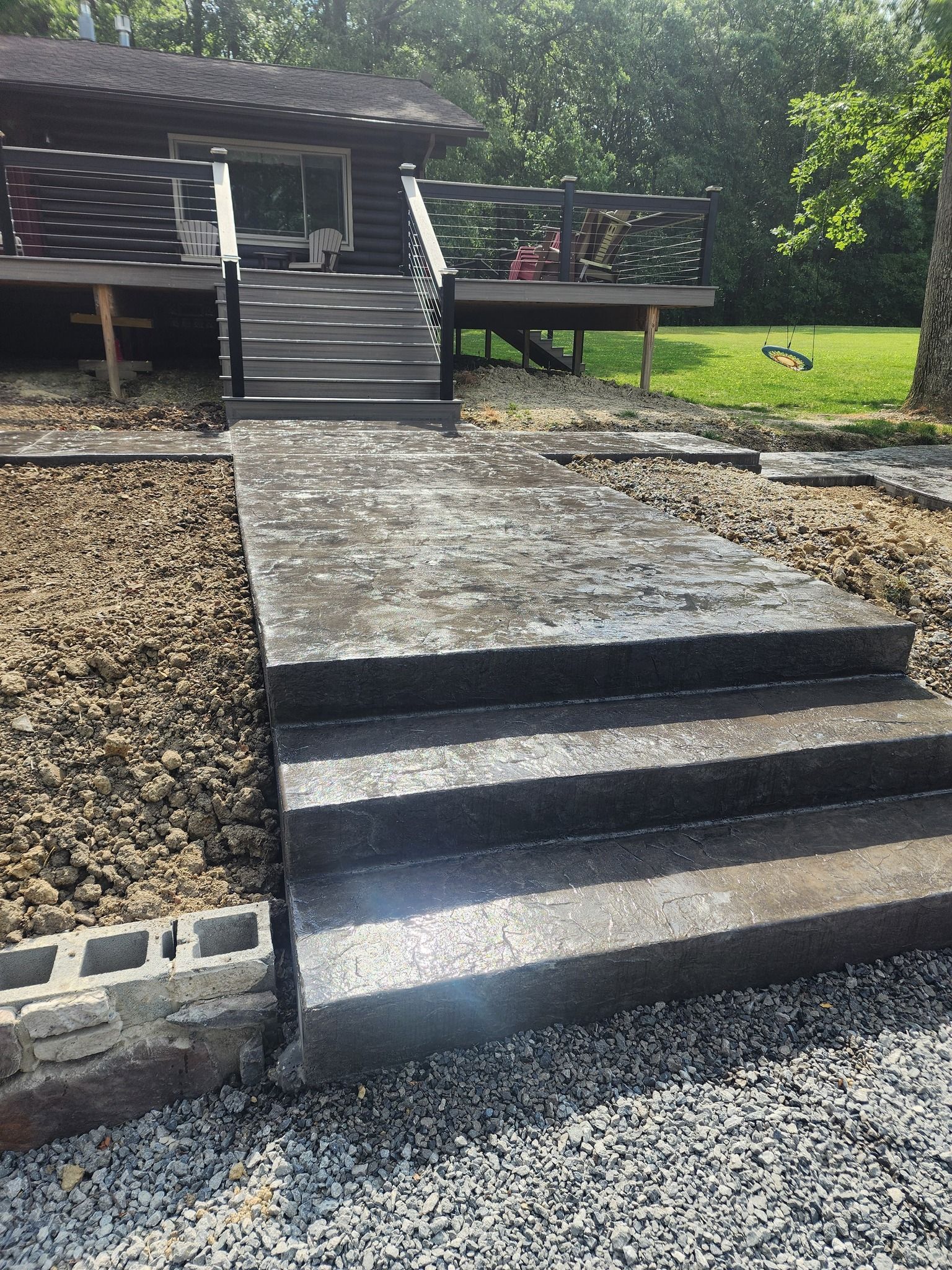 A set of stairs leading up to a house with a deck.