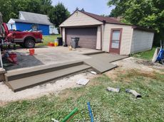 A red truck is parked in front of a garage.
