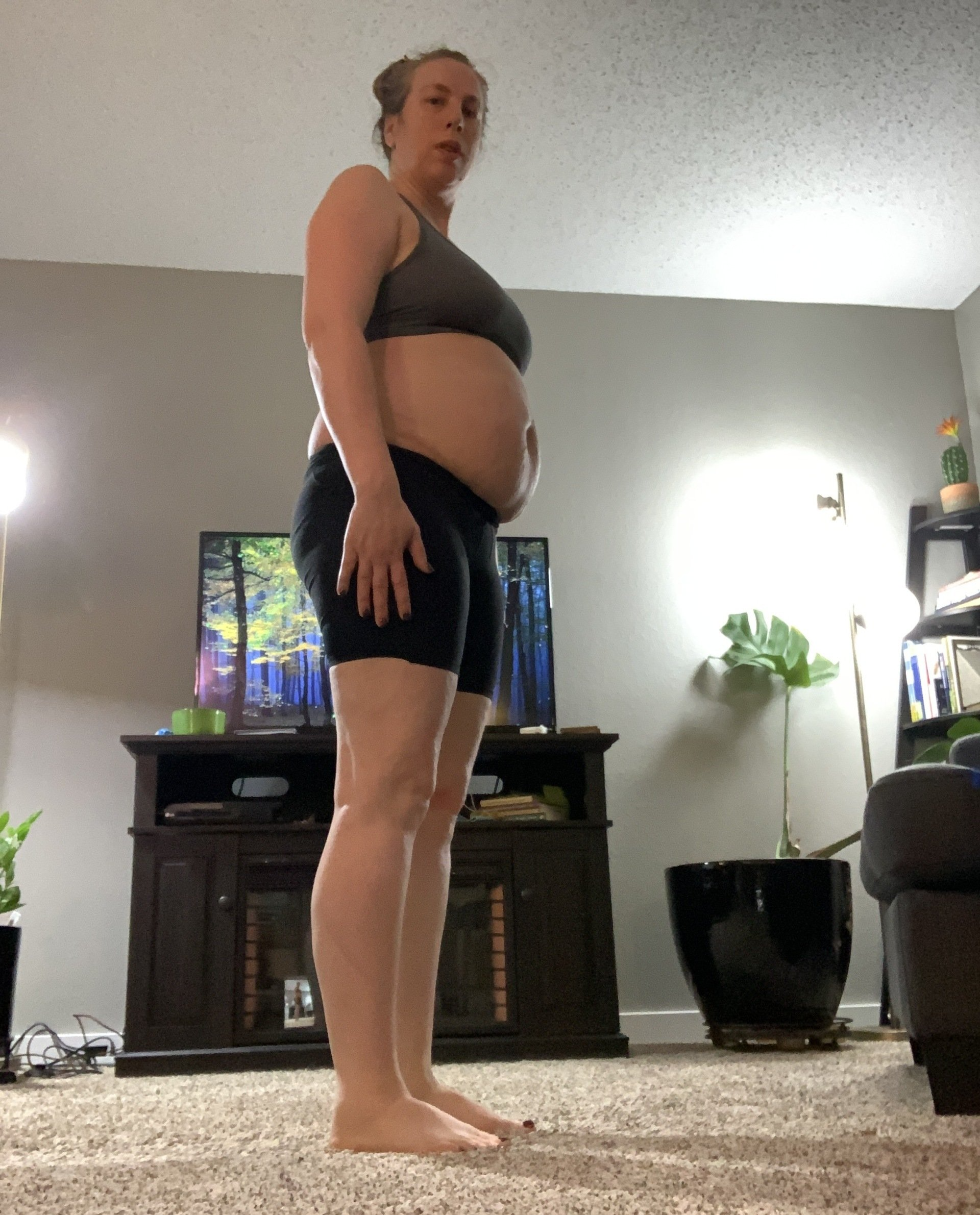 A woman with a large belly is standing in a living room