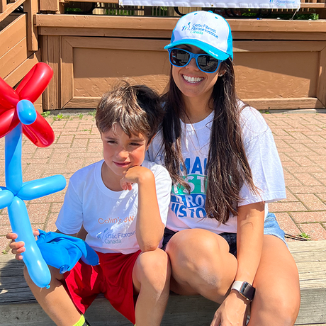 Marylou and her son, Colin, who has CF, are sitting outside at the 2025 Walk.