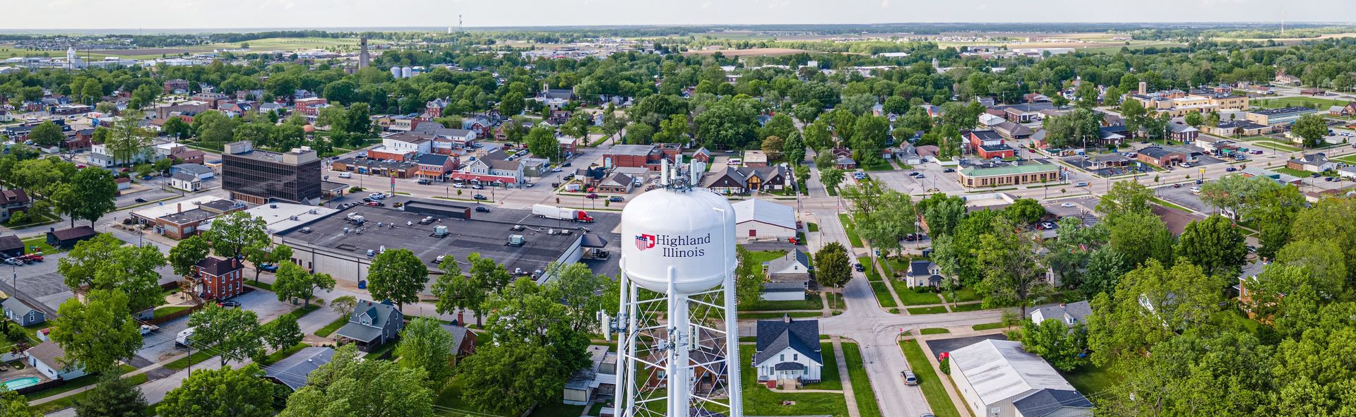 Welcome sign for Troy, brick structure, with city name and logos for service clubs.