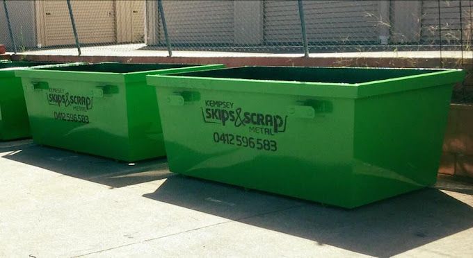 Two Green Skip Bins Sitting In Front Of A Retaining Wall — Kempsey Skip Bins In Macksville, NSW