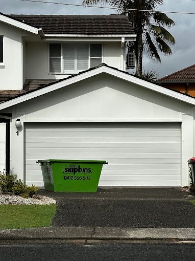 A Green Skip Bin Sitting In Front Of A White House — Kempsey Skip Bins In Willawarrin, NSW