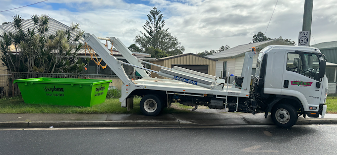 A Green Skip Bin Sitting Behind A White Flatbed Truck — Kempsey Skip Bins In Macksville, NSW