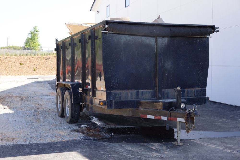 A Dumpster Trailer Is Parked In A Parking Lot In Front Of A Building — Kempsey Skip Bins In Crescent Head, NSW