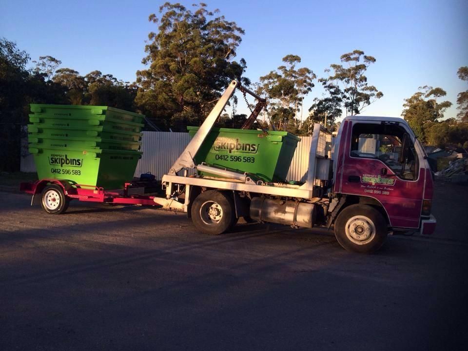 Truck with Green Skip Bins on Trailer and Truck Bed — Kempsey Skip Bins In Stuarts Point, NSW