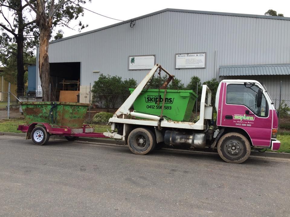 A Pink Skip Bin Truck with A Green Skip Bin and Trailer Parked on A Road — Kempsey Skip Bins In Crescent Head, NSW