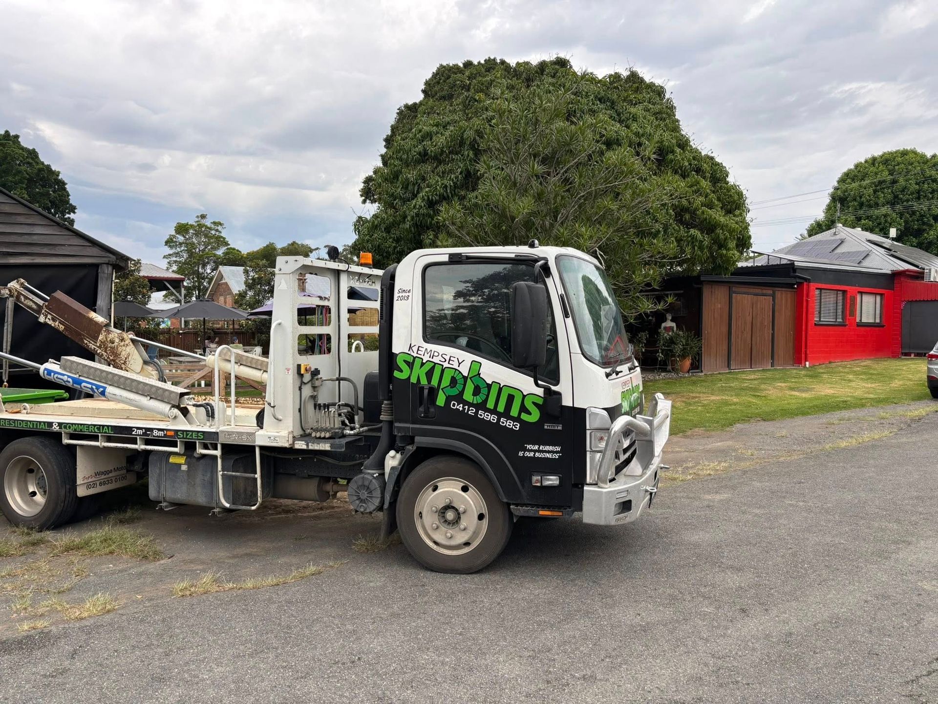 White Skip Bin Truck Parked on Gravel in Front of A Red Building — Kempsey Skip Bins In Nambucca, NSW