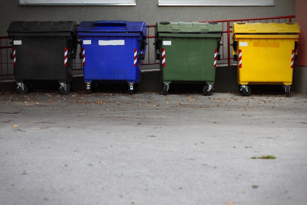 A Row Of Trash Cans Are Lined Up In A Parking Lot — Kempsey Skip Bins In Telegraph Point, NSW
