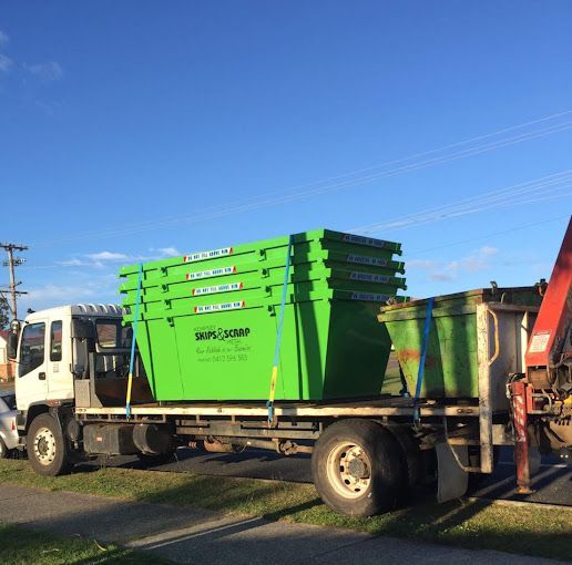 A Green Trash Can Is Sitting On The Side Of A Road In A Park — Kempsey Skip Bins In South Kempsey, NSW