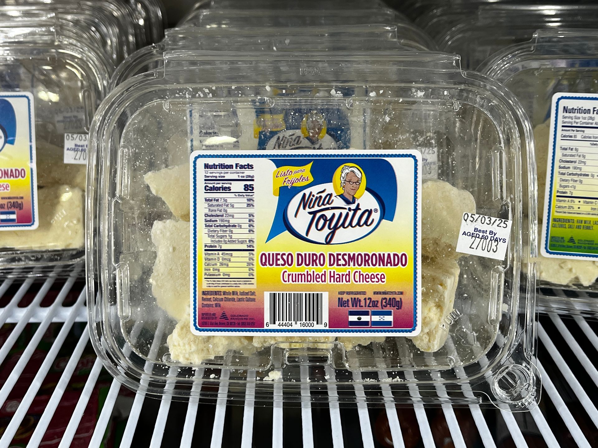 A plastic container of queso duro deshidratado is sitting on a shelf.