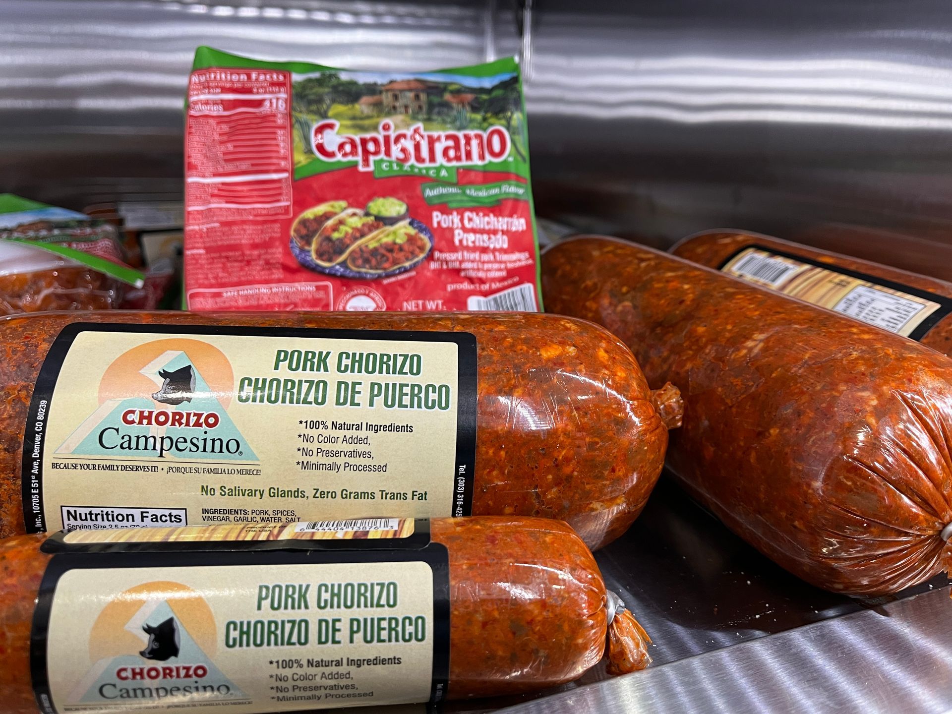 A package of pork chorizo is next to some sausages