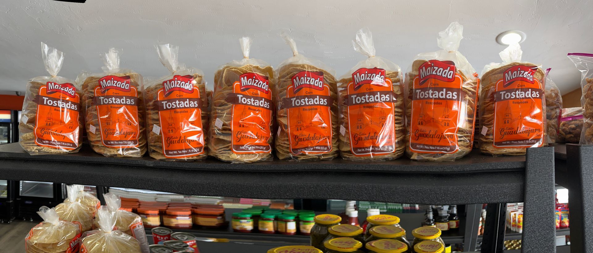 A bunch of bags of food are sitting on a shelf.