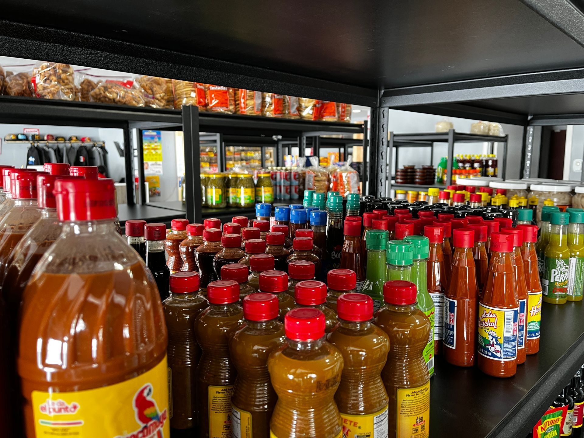A store shelf filled with lots of bottles of sauces