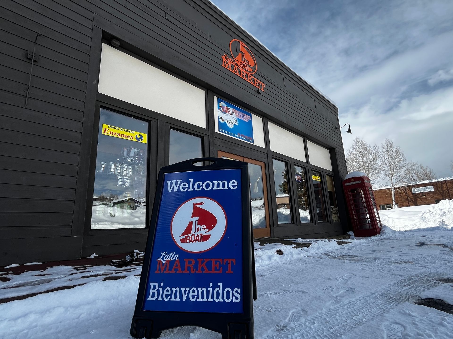 A sign in front of a store that says welcome market bienvenidos