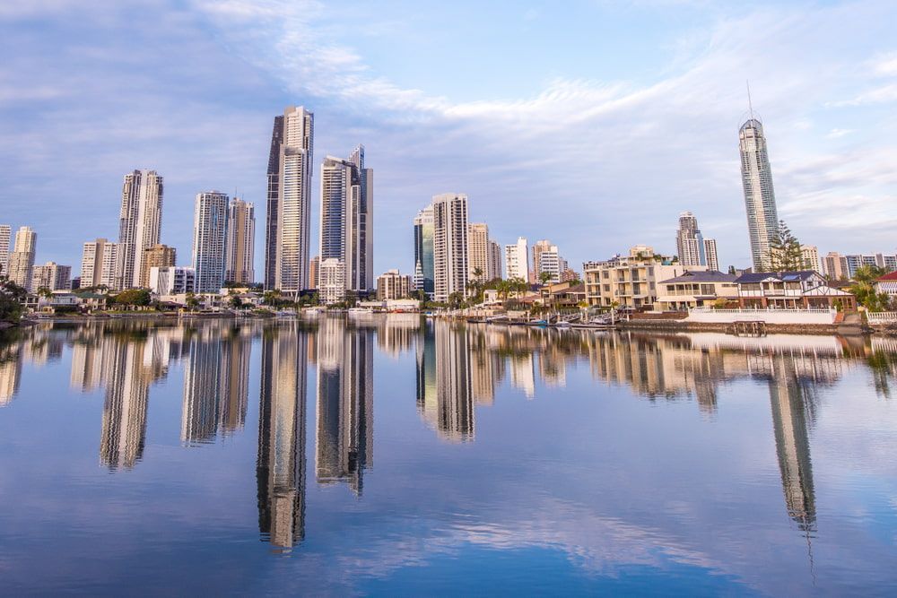 A City Skyline Is Reflected In A Body Of Water — Miami Denture Clinic In Miami, QLD
