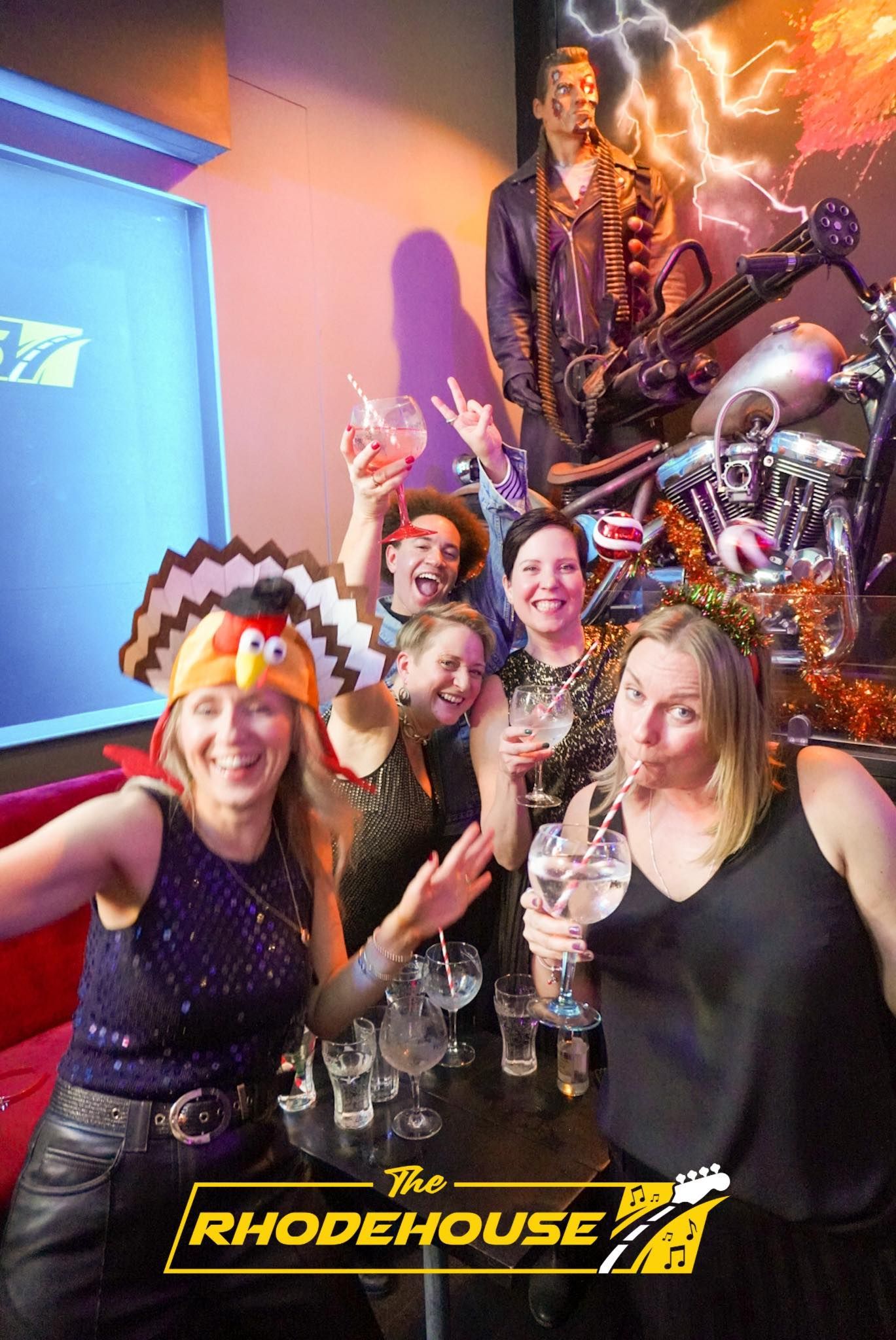 A group of people are posing for a picture in front of a motorcycle.