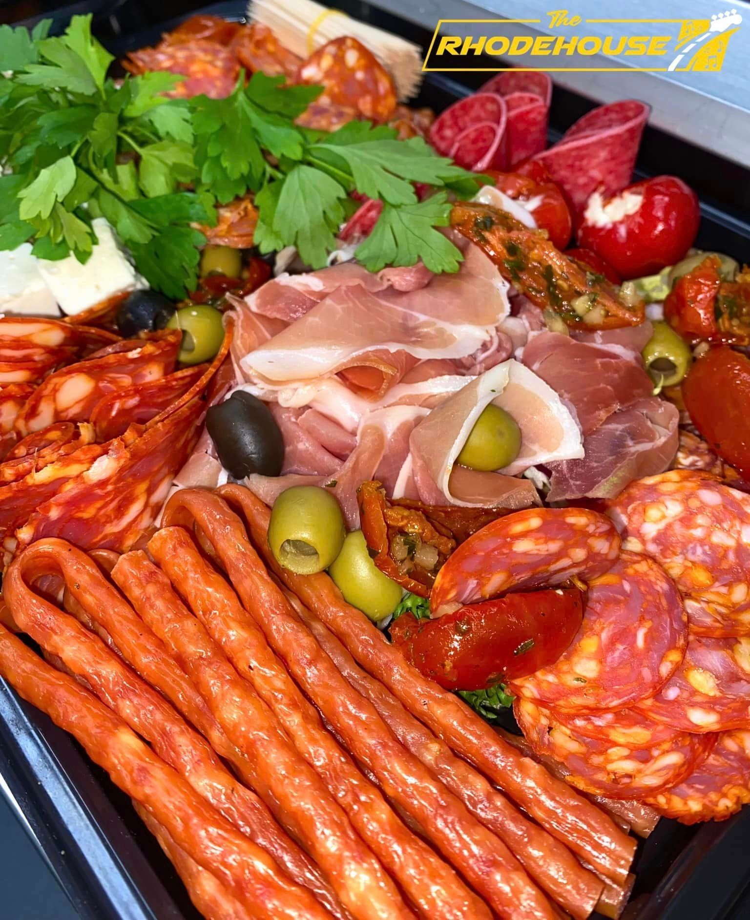 A black tray filled with a variety of meats and vegetables.