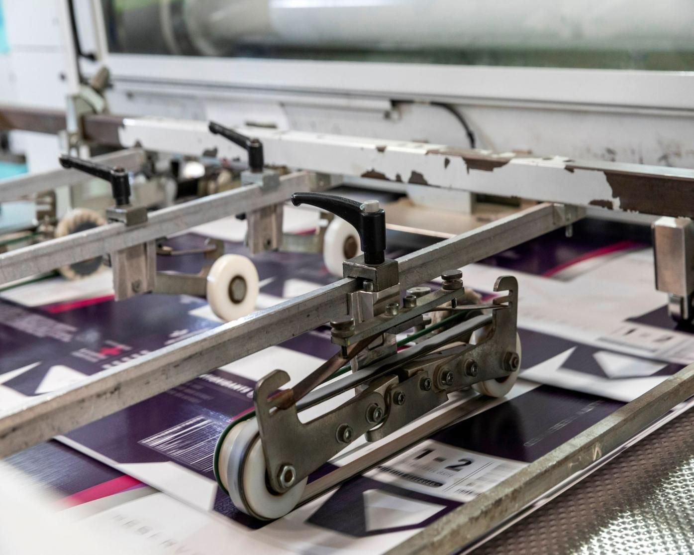 A Machine Is Moving A Piece Of Paper On A Conveyor Belt — Classic Design & Print in Svensson Heights, QLD