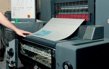 Person is Holding a Roll of Red and White Paper — Classic Design & Print in Svensson Heights, QLD