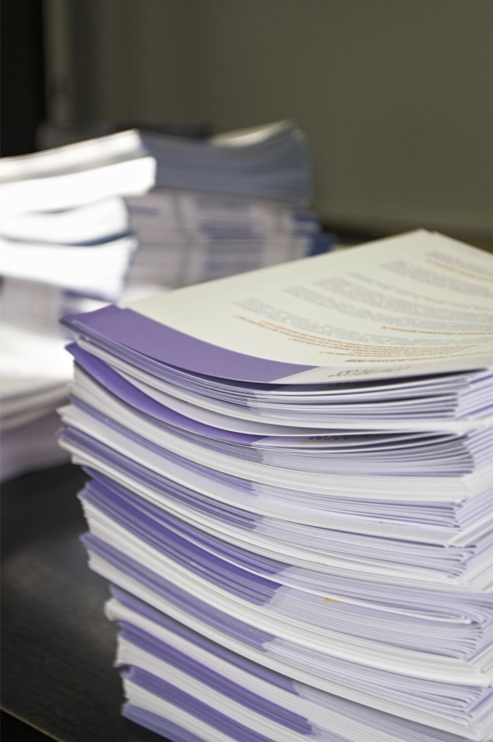 A Stack Of Papers Is Sitting On A Table — Classic Design & Print in Svensson Heights, QLD