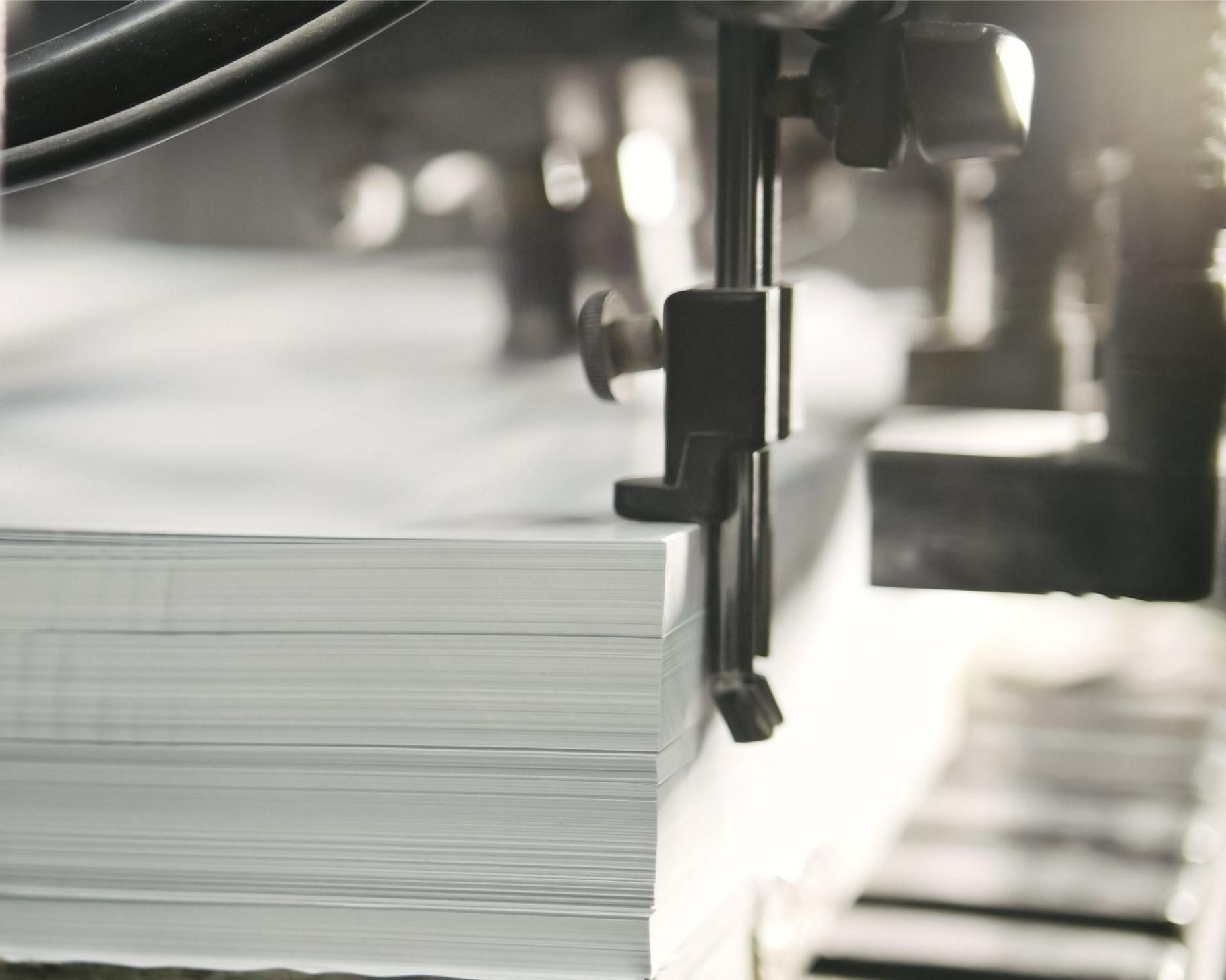 A Machine Is Cutting A Stack Of Paper In A Factory — Classic Design & Print in Svensson Heights, QLD