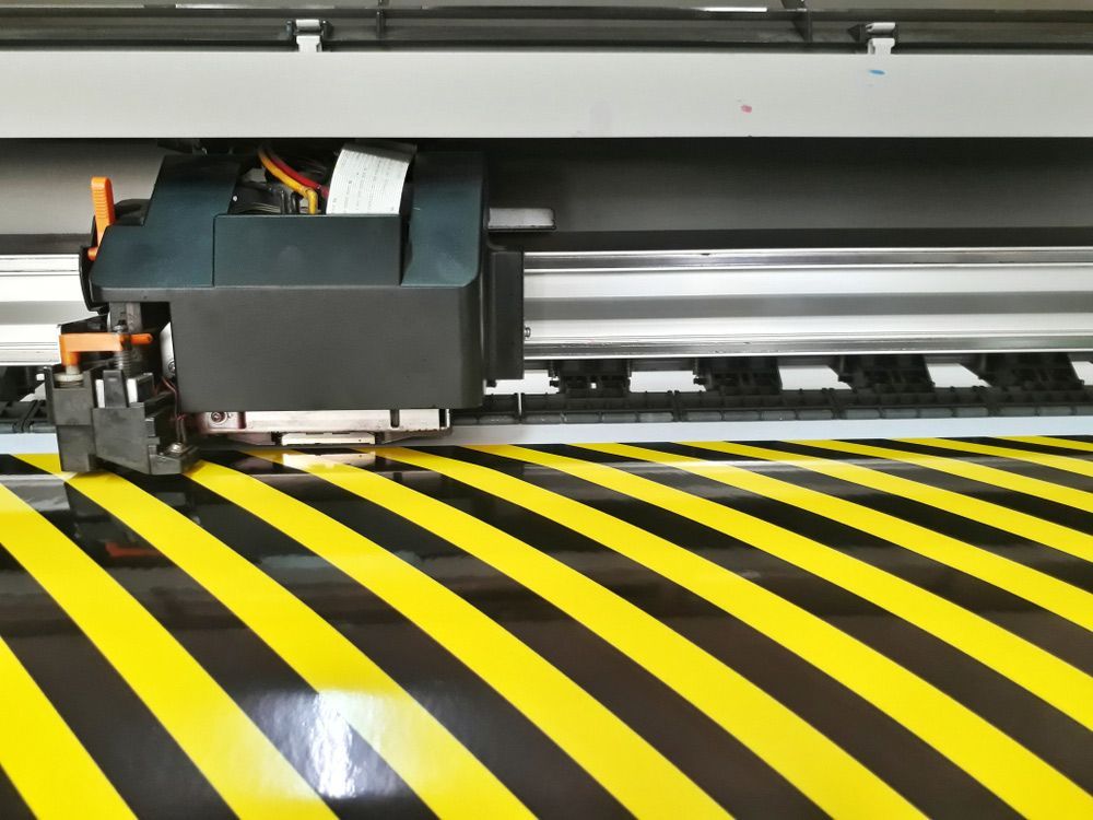 Yellow and Black Striped Floor is Being Cut by a Machine — Classic Design & Print in Bundaberg, QLD
