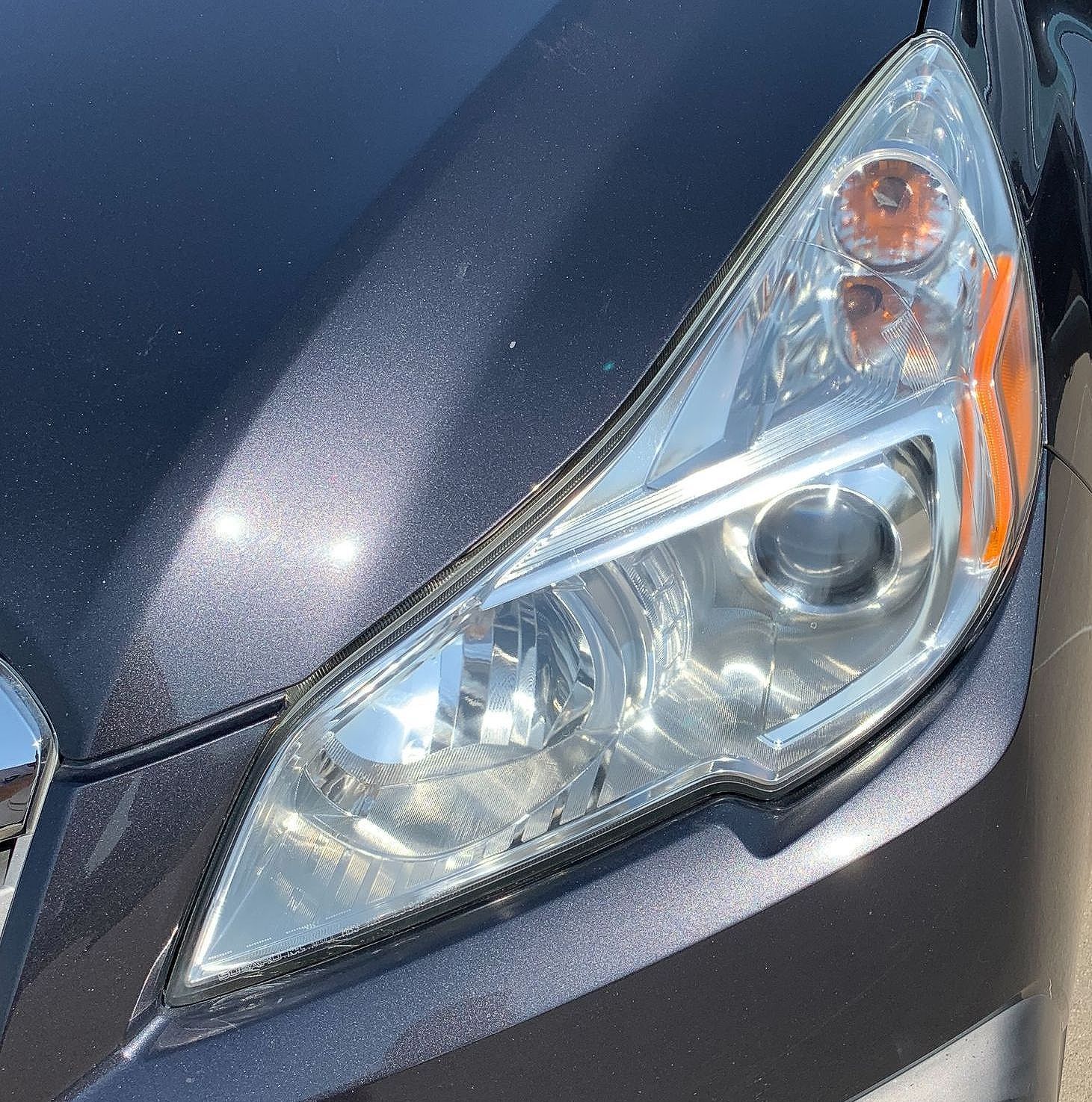 A close up of a car 's headlight and hood