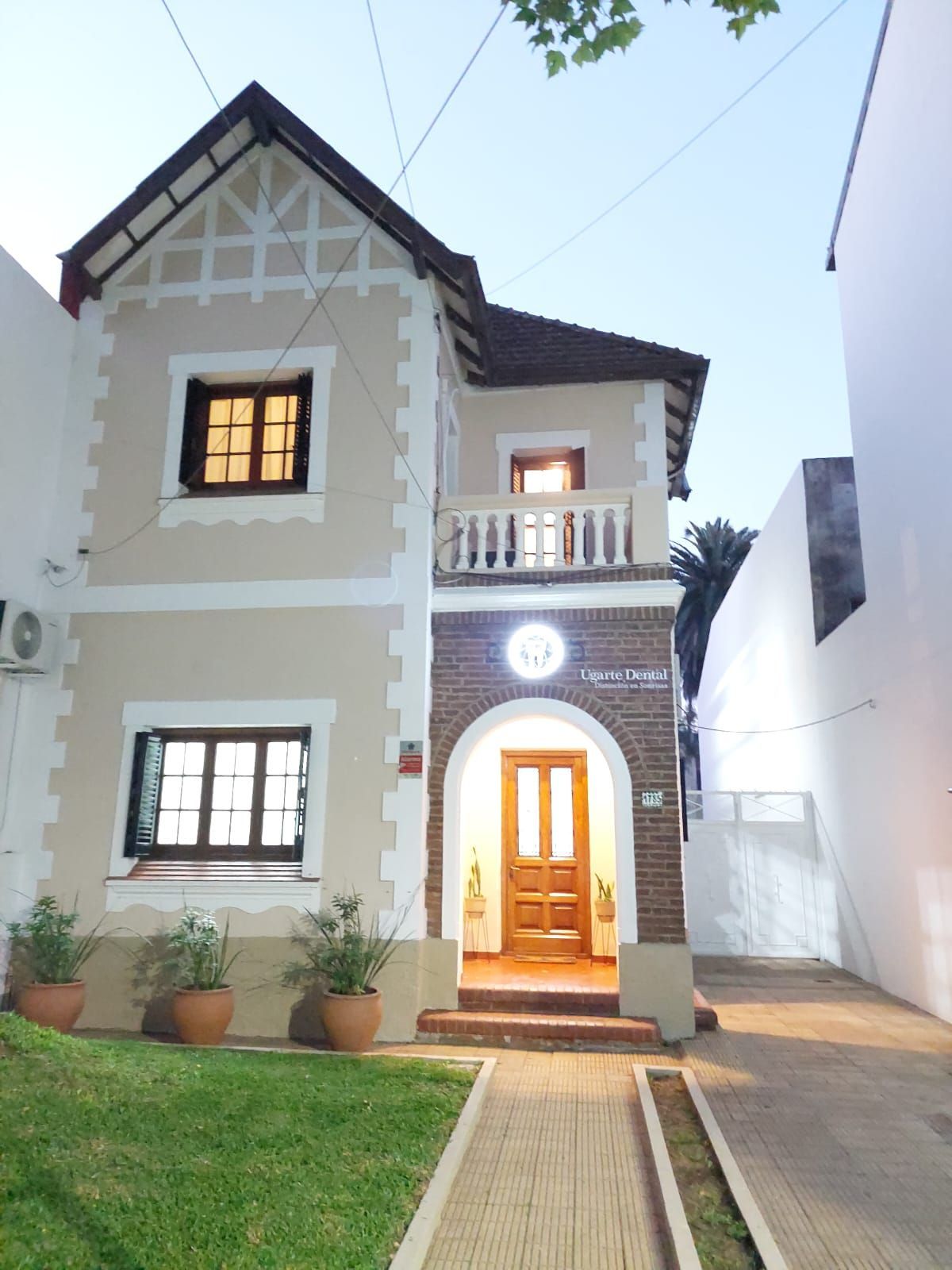 Una casa grande con fachada de ladrillo y balcón.