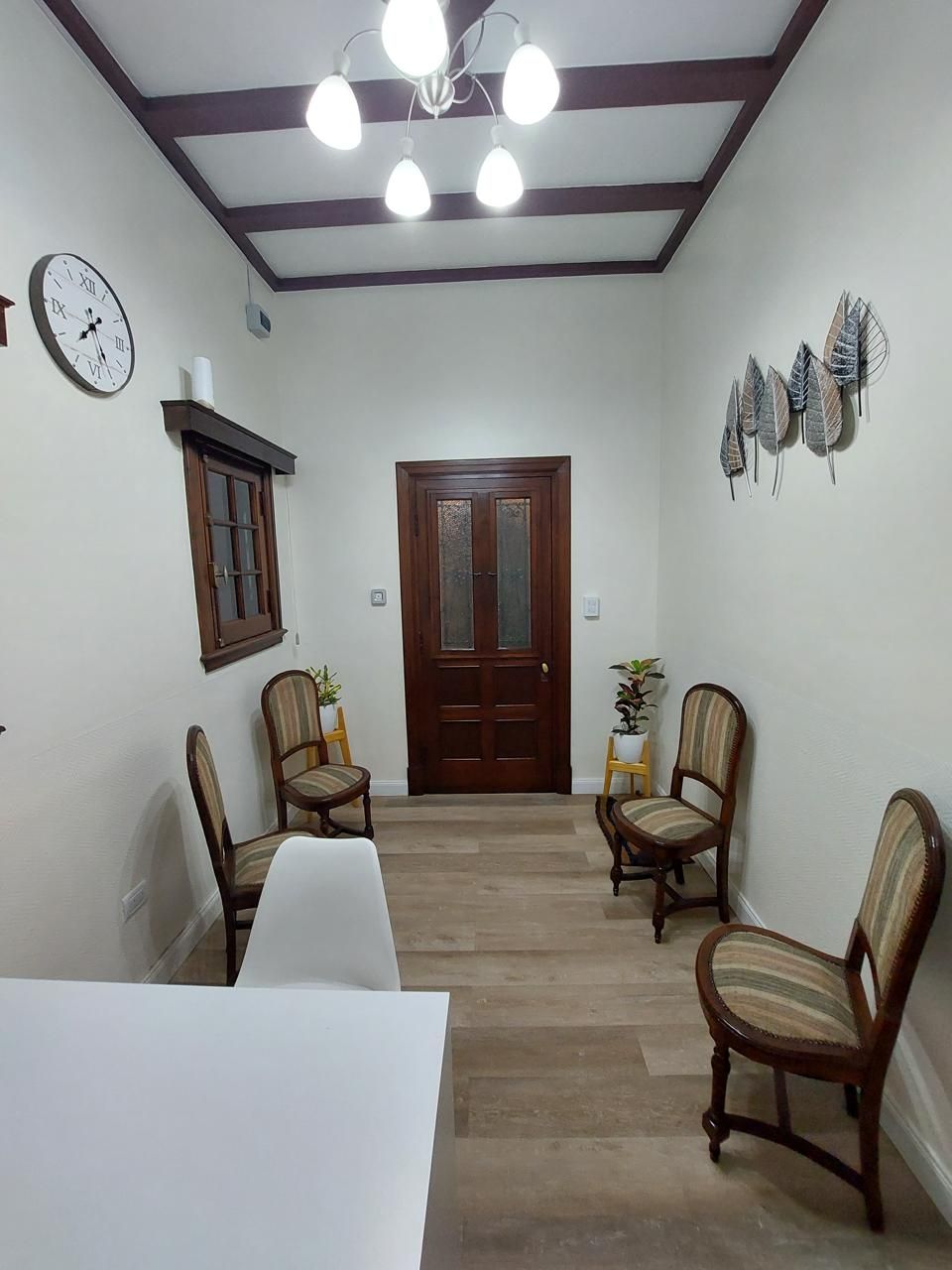 Una sala de espera con sillas y un reloj en la pared.