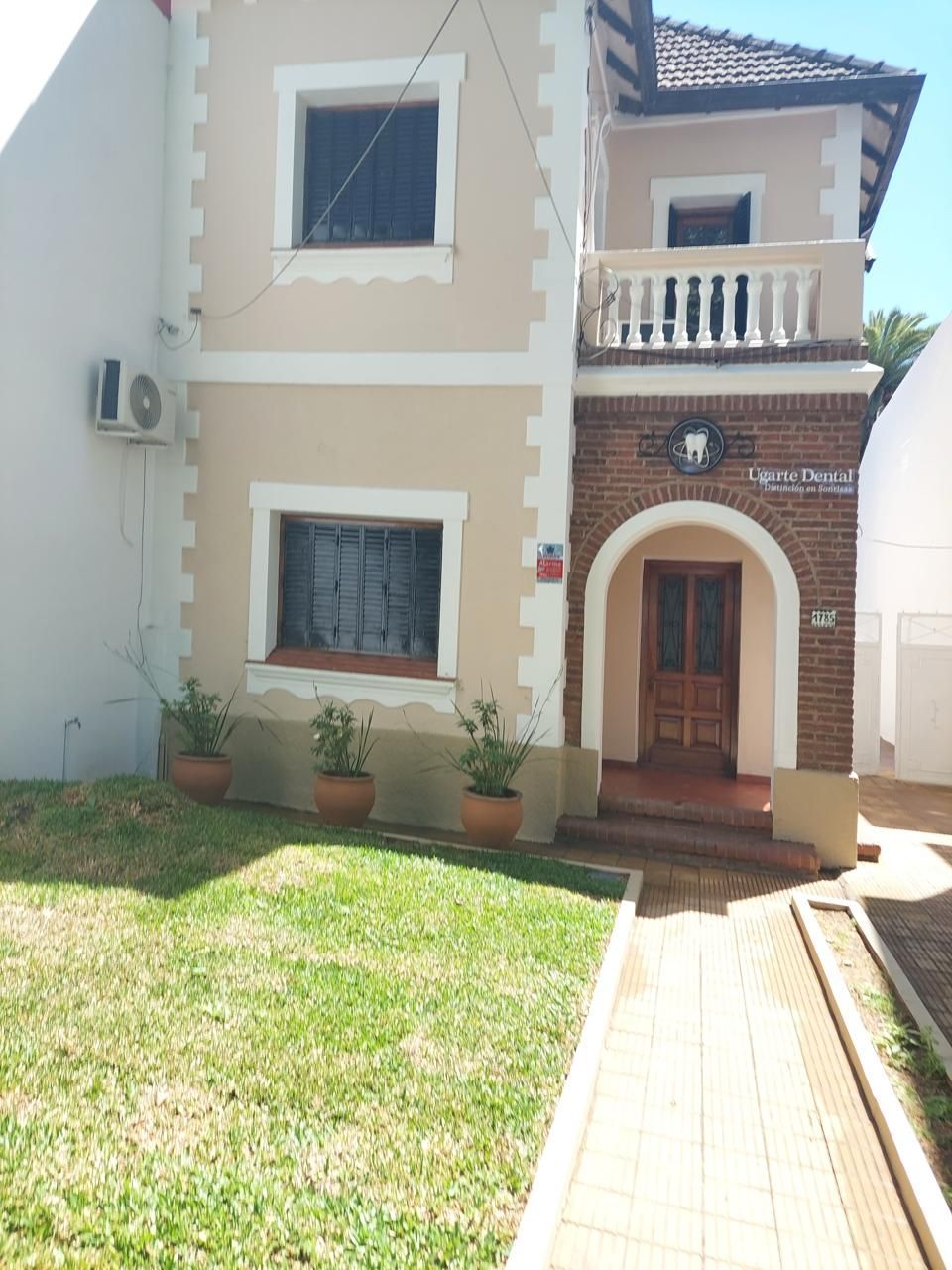 Una casa con un arco de ladrillo y un balcón