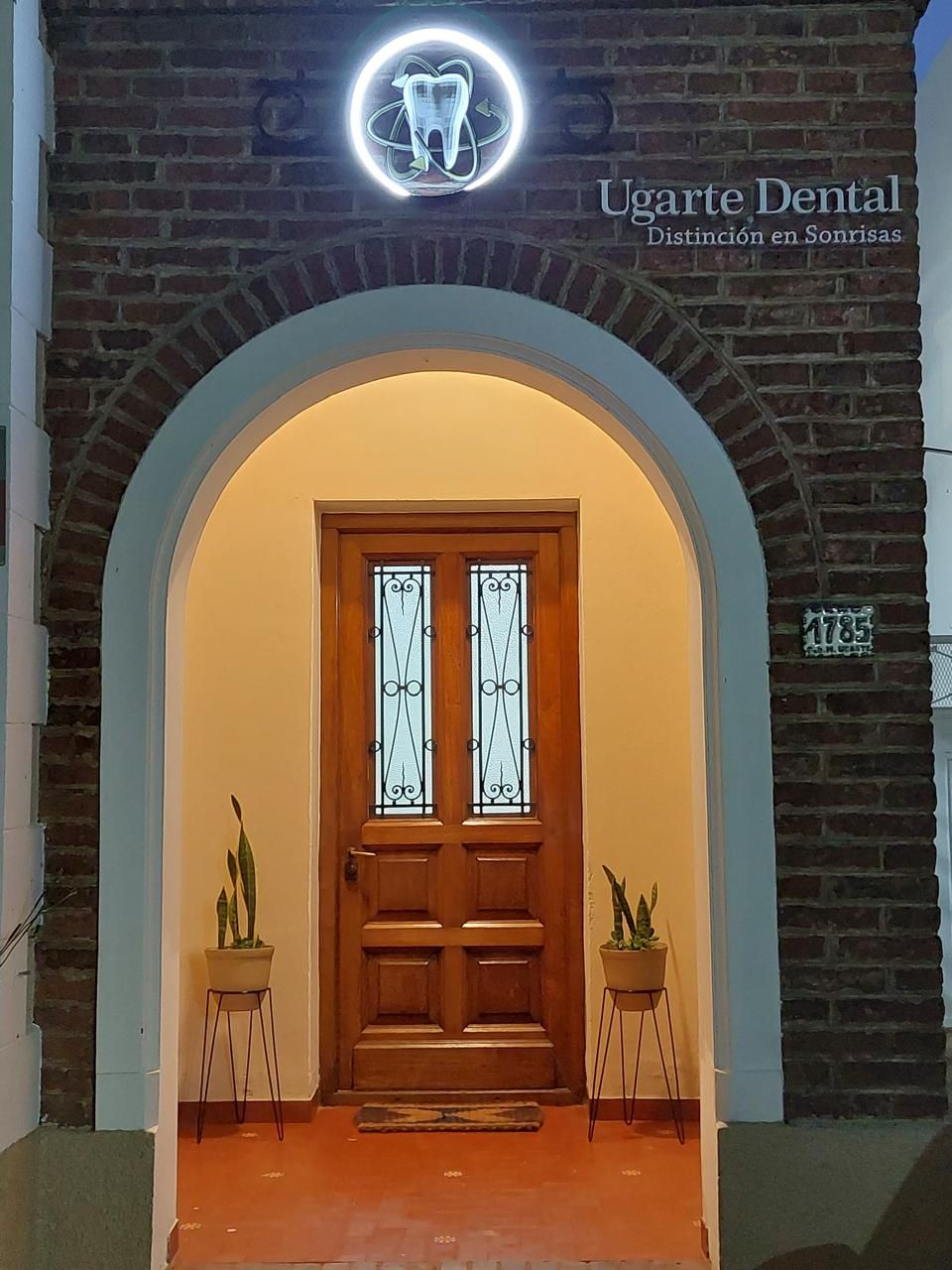 Un consultorio dental con una puerta de madera y una pared de ladrillo.