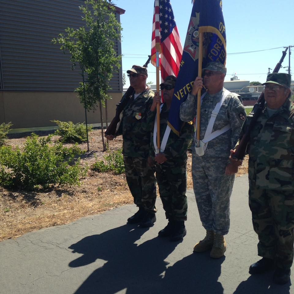 A group of soldiers holding flags one of which has the word veteran on it