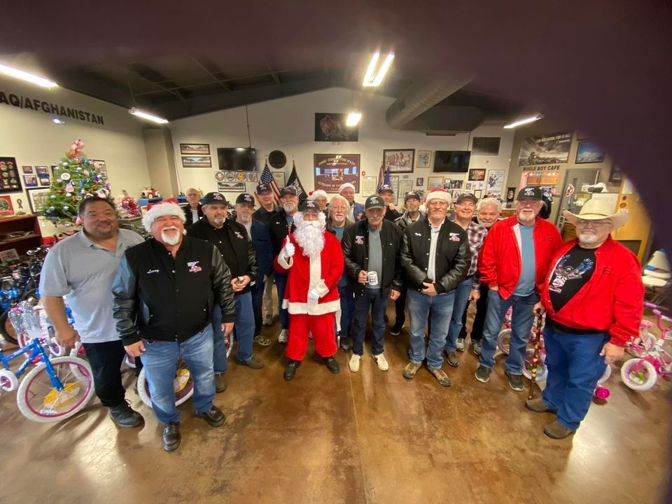 A group of men are posing for a picture with santa claus in a room.