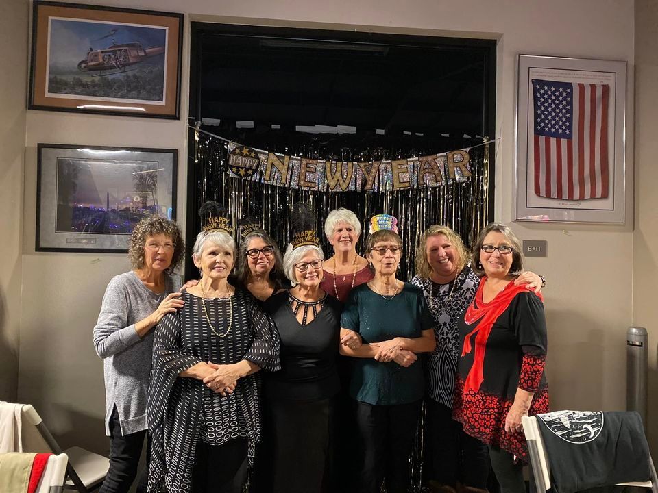 A group of women are posing for a picture in a room.