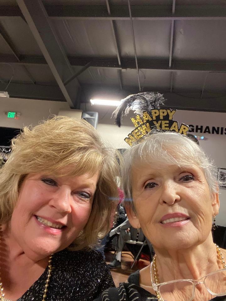 Two women are posing for a picture together and one of them is wearing a happy new year crown.