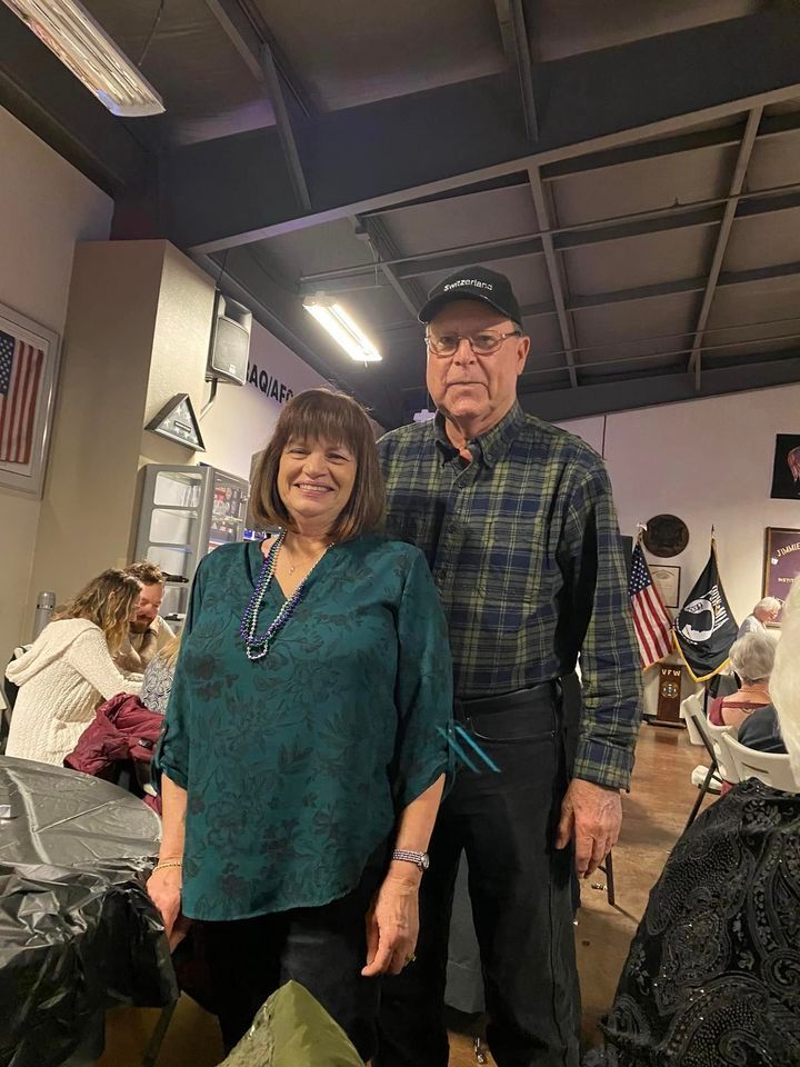 A man and a woman are standing next to each other in a room.